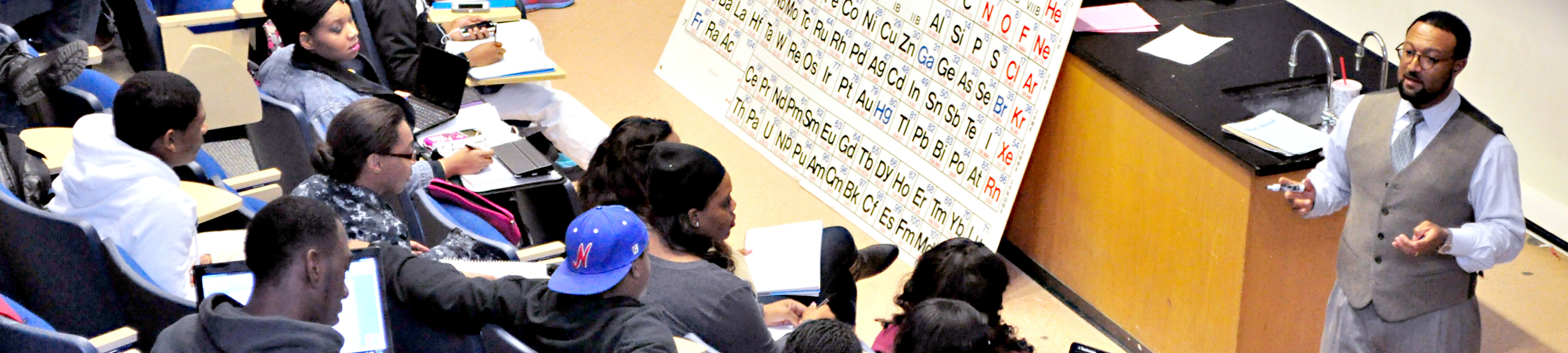 Black male chemistry teacher in lecture hall