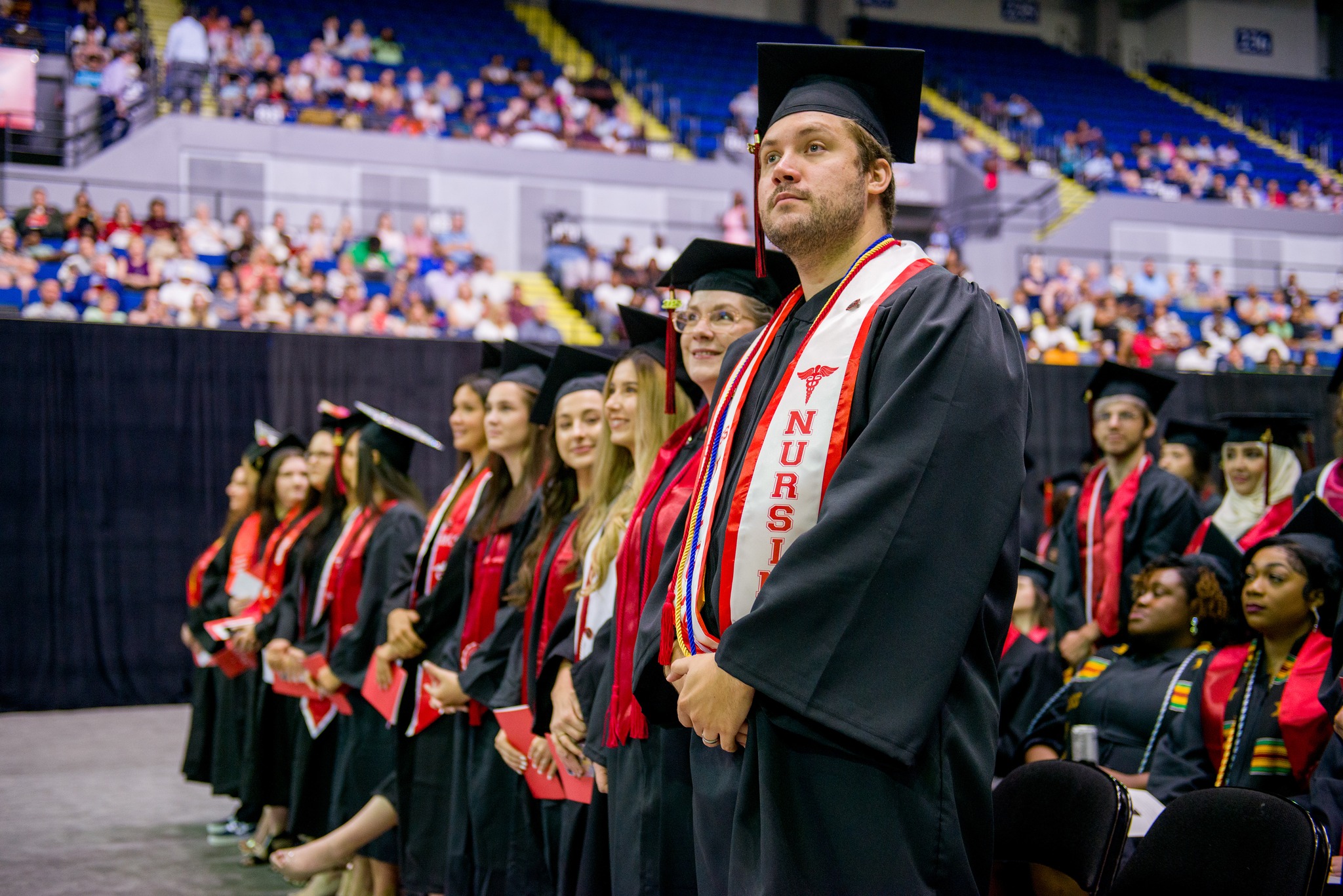 A student stands during commencement ceremonies