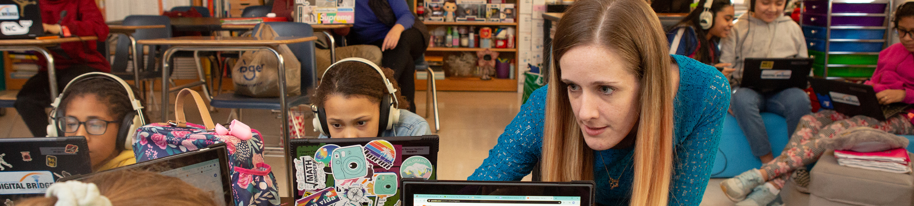 teacher helping student at the computer