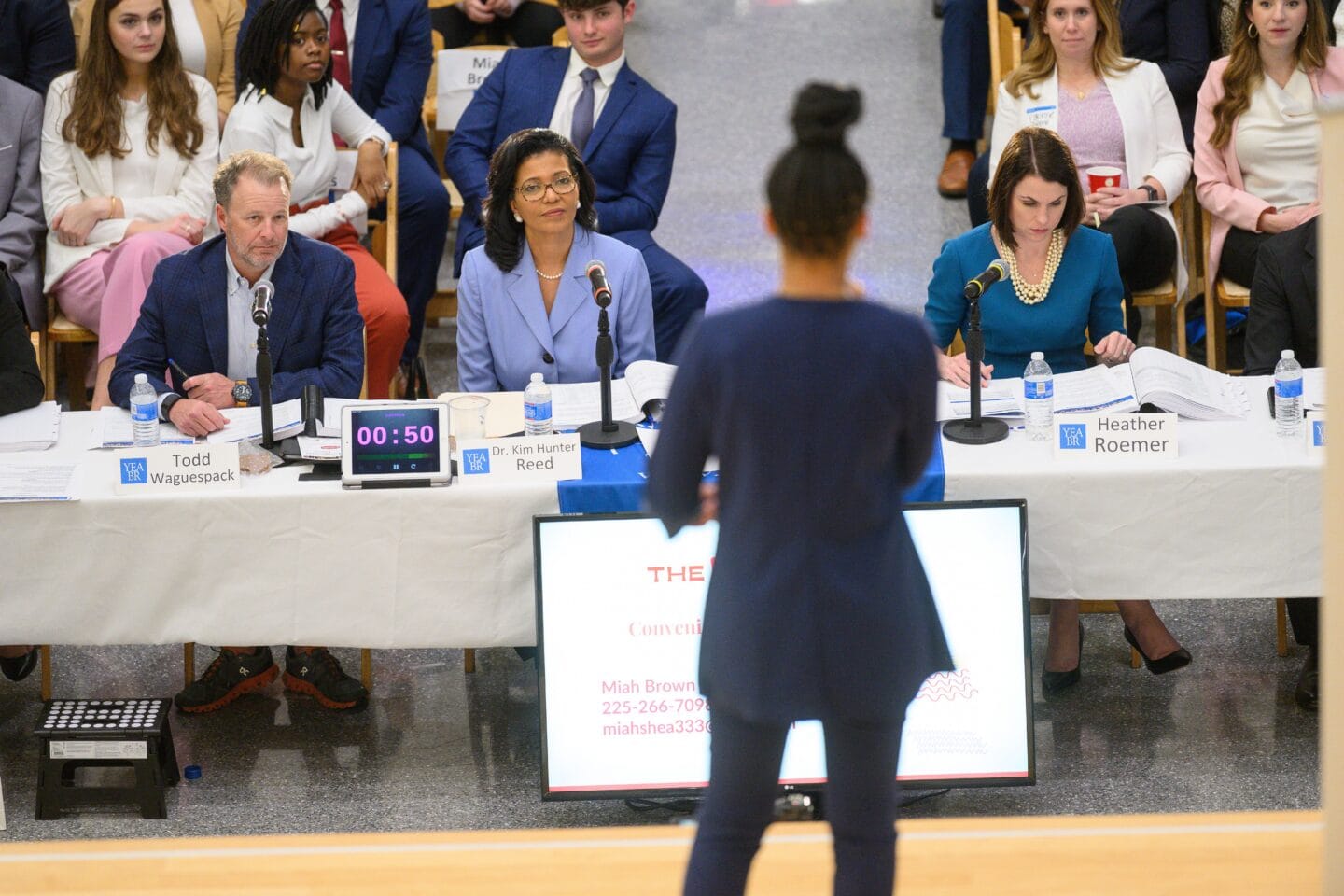 Commissioner Kim Hunter Reed listens intently at the Young Entrepreneurs Academy Pitch Competition.